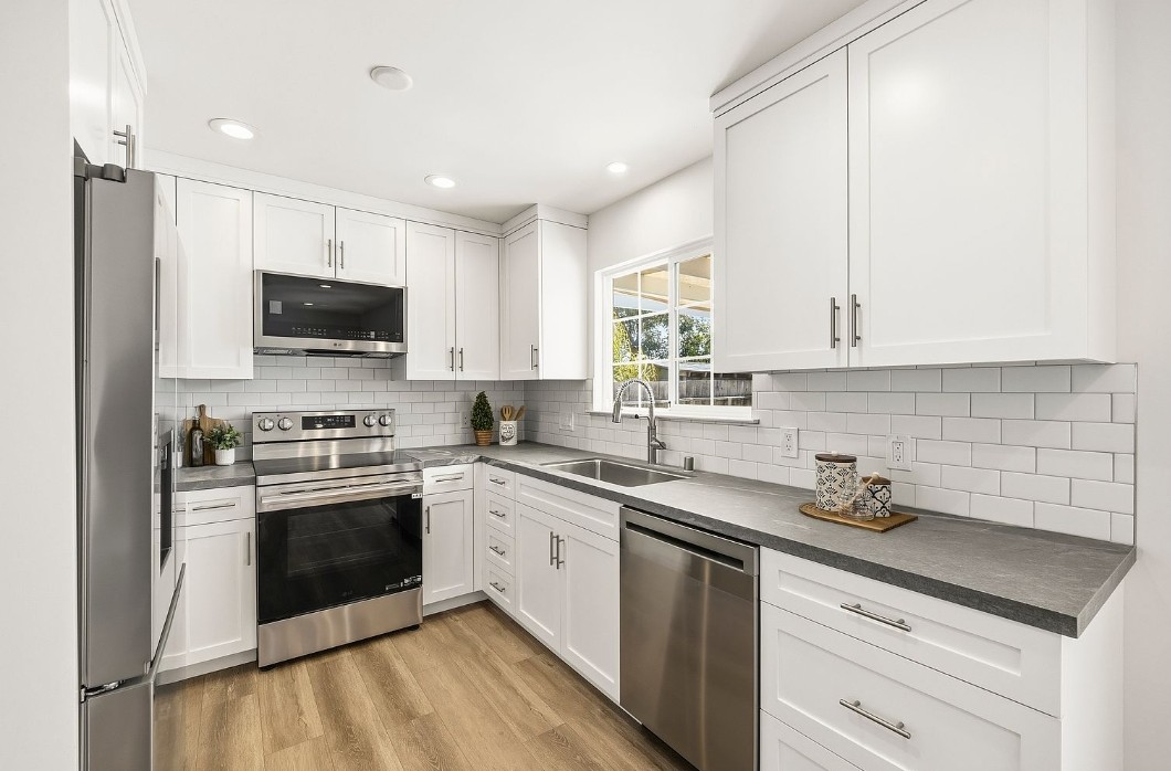 Remodeled kitchen with white shaker cabinets, subway tile and stainless appliances